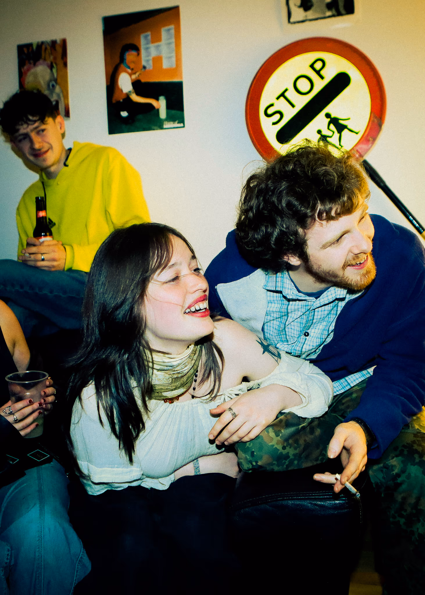 Friends laughing on a sofa with SIP cans